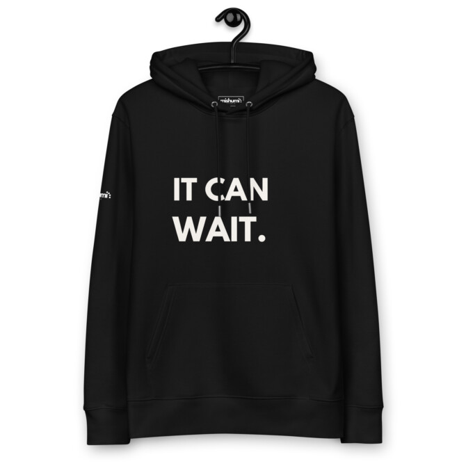 Minimalist black 'It Can Wait' hoodie hanging, perfect for casual wear and downtime.